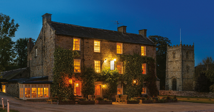 View of the Rose and Crown inn at night time in the village of Romaldkirk